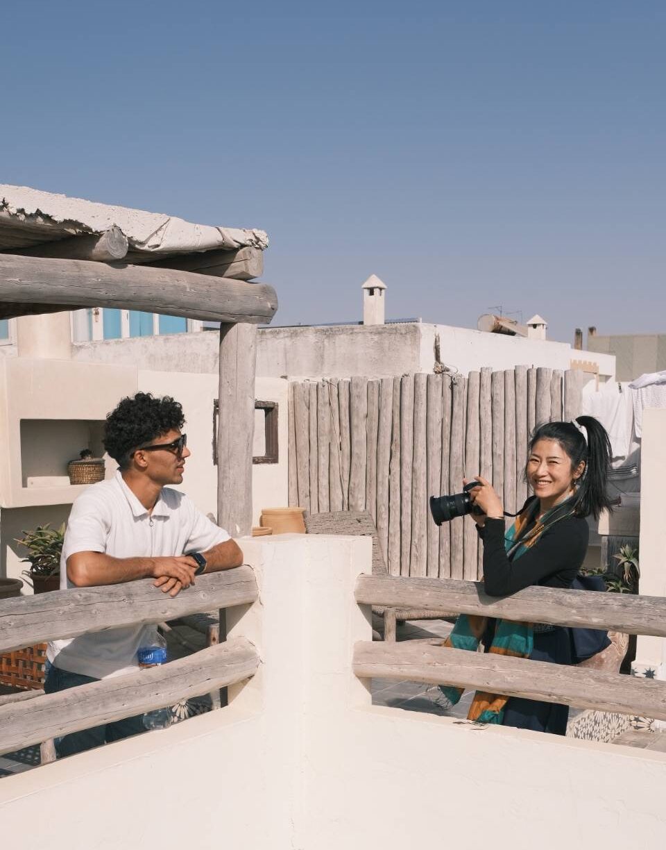 Sweet interracial couple holding hands on the historic Essaouira ramparts at sunset